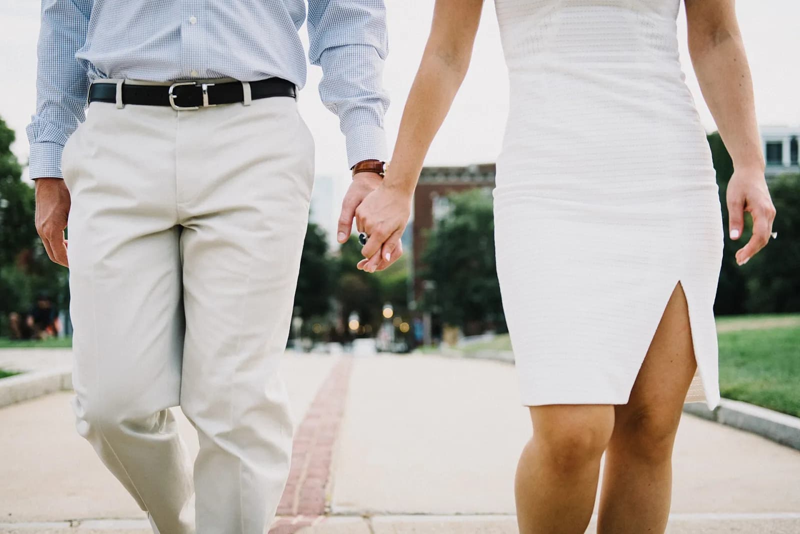 A couple walking hand in hand along a city path