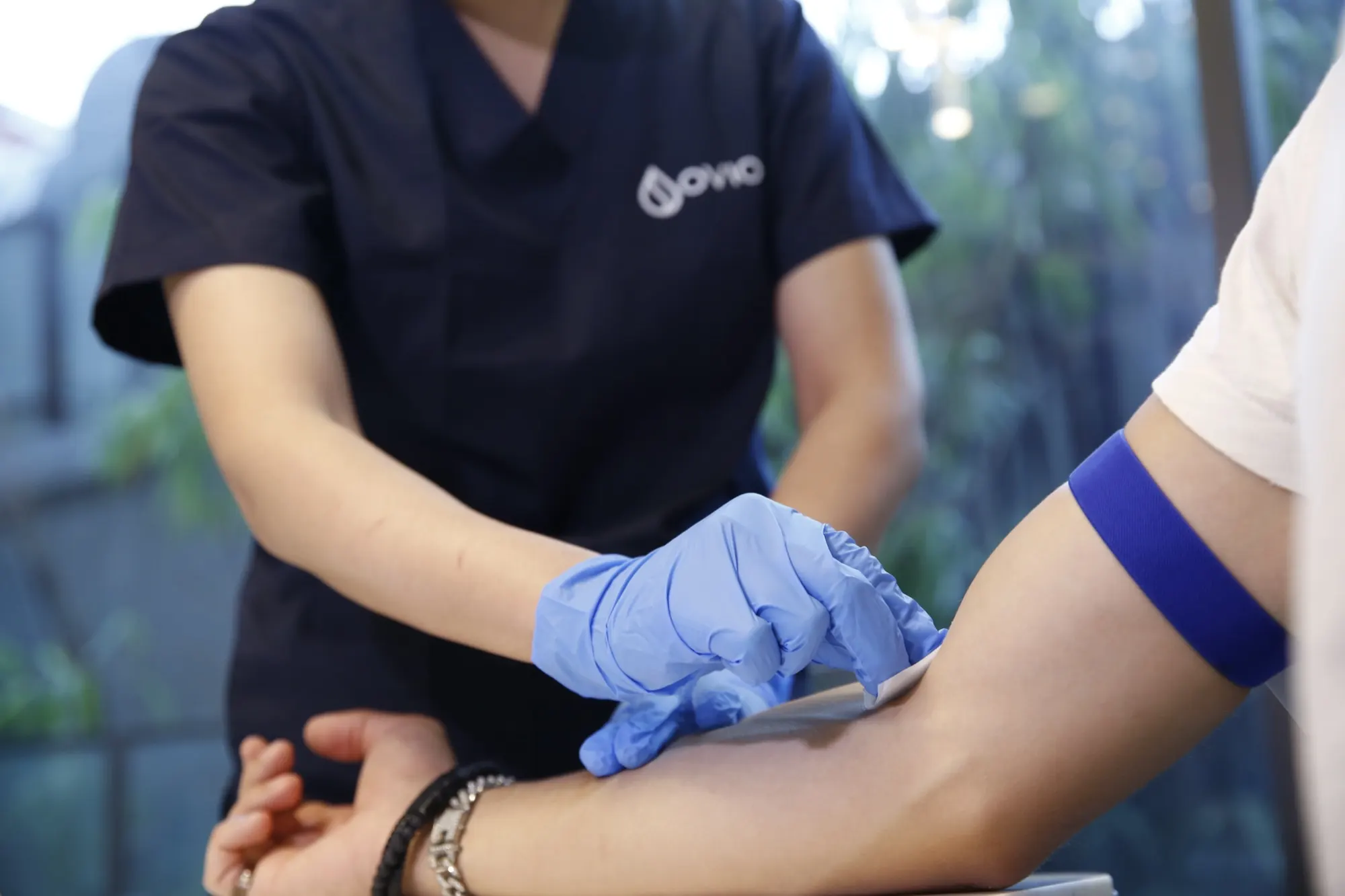 A nurse taking a blood sample from a patient's arm for laboratory testing